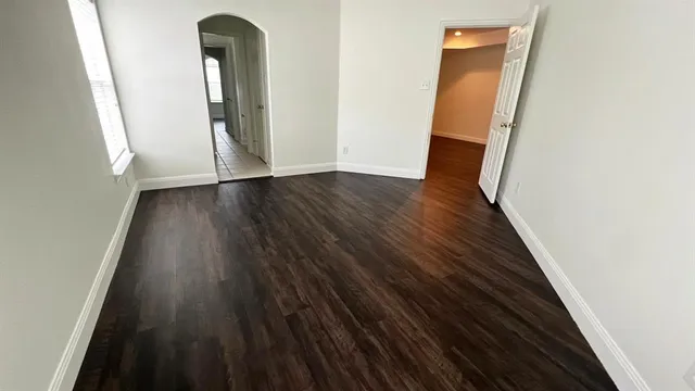 a bedroom with bed a mirror and a potted plant