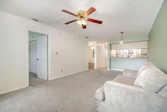 a living room with furniture and a ceiling fan
