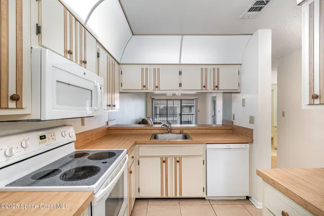 a kitchen filled with white cabinets and white appliances