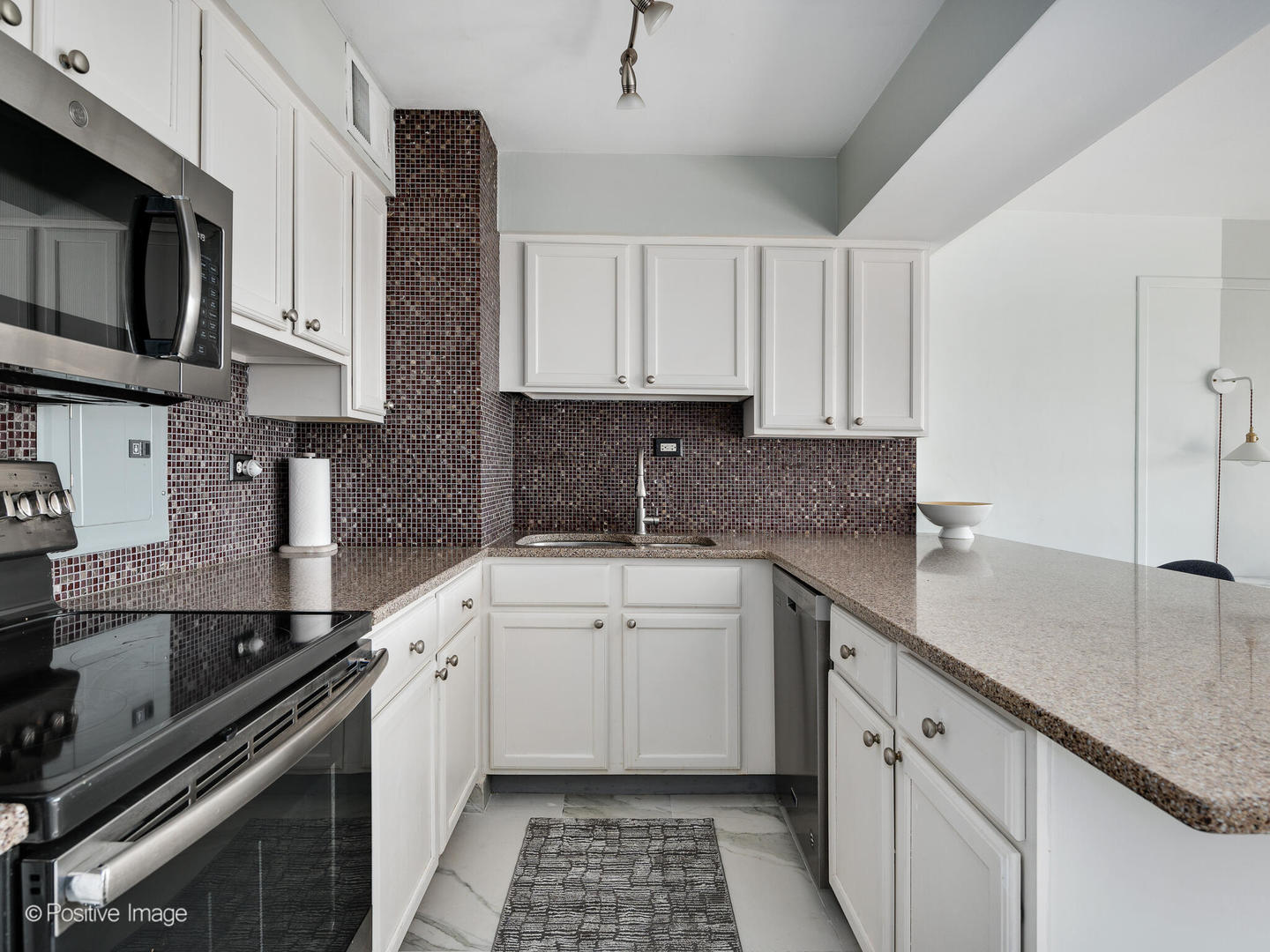 6030 North Sheridan Road, Unit 703 Chicago, IL 60660 - Photo 12 of 15 a kitchen with a sink stove top oven and cabinets