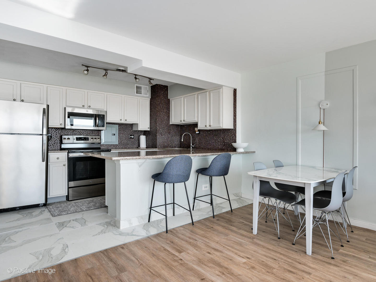 6030 North Sheridan Road, Unit 703 Chicago, IL 60660 - Photo 9 of 15 a kitchen with a dining table chairs and refrigerator