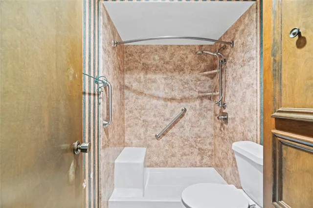 a bathroom with a toilet and a shower