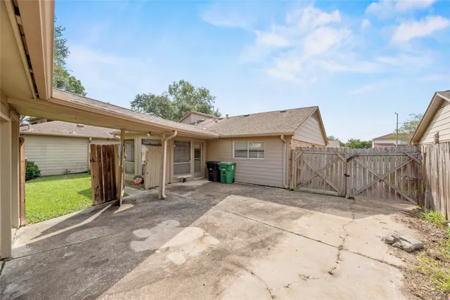 a view of a house with wooden fence next to a yard