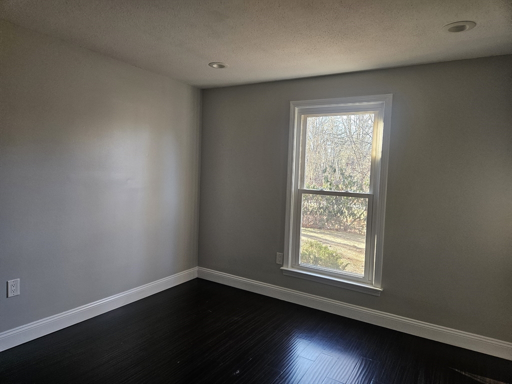 10 Shadowbrook Lane, Unit 19 Milford, MA 01757 - Photo 5 of 11 an empty room with wooden floor and windows