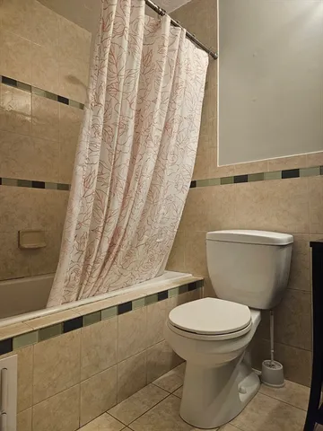 a white toilet sitting next to a shower