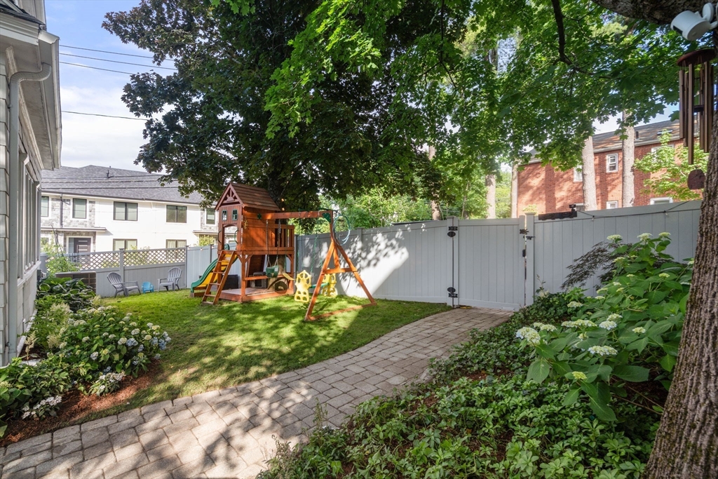 95 Langley Road, Unit 1 Newton, MA 02459 - Photo 20 of 22 a view of a backyard with plants and large tree