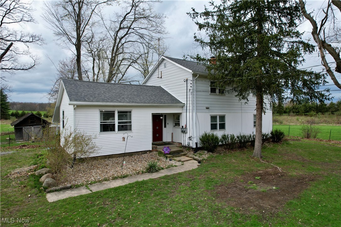 8195 Nichols Road Windham, OH 44288 - Photo 26 of 41 View of front of property featuring fence, a shingled roof, a front lawn, and a chimney