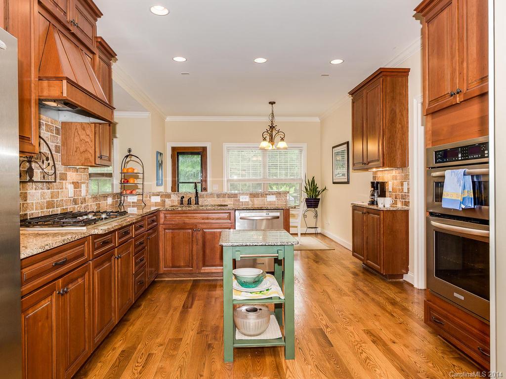 2641 Houston Branch Road Charlotte, NC 28270 - Photo 9 of 24 a kitchen with stainless steel appliances granite countertop a stove top oven a sink dishwasher and a stove with wooden floor