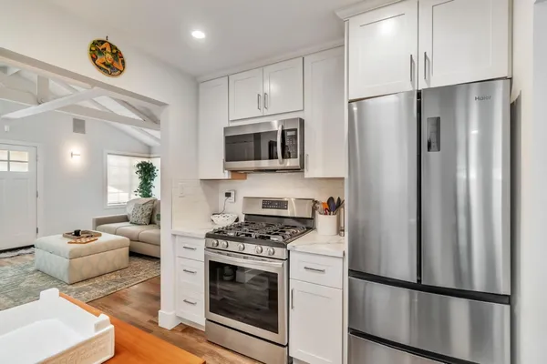 a kitchen with stainless steel appliances a refrigerator stove and microwave