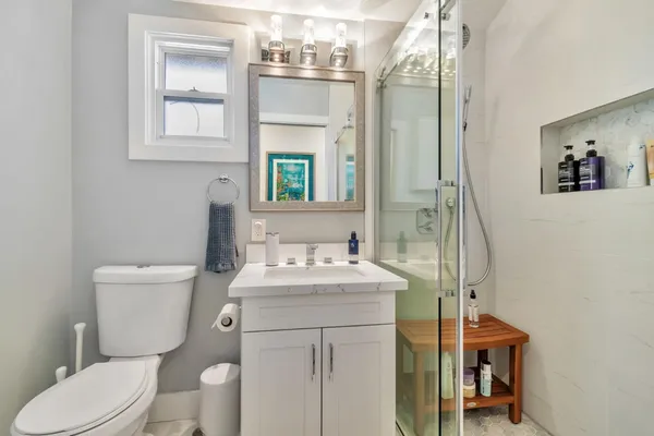 a bathroom with a toilet a sink and a mirror