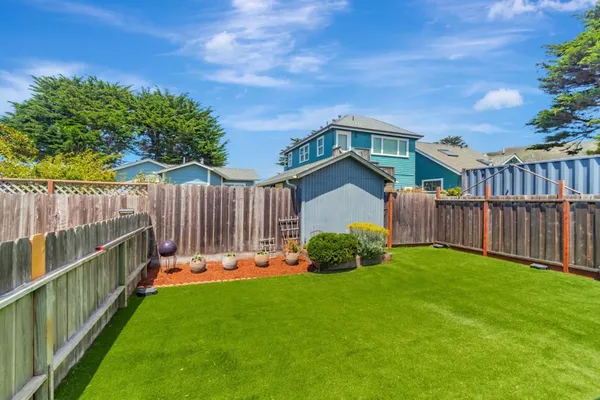 a view of a backyard with a small cabin and wooden fence