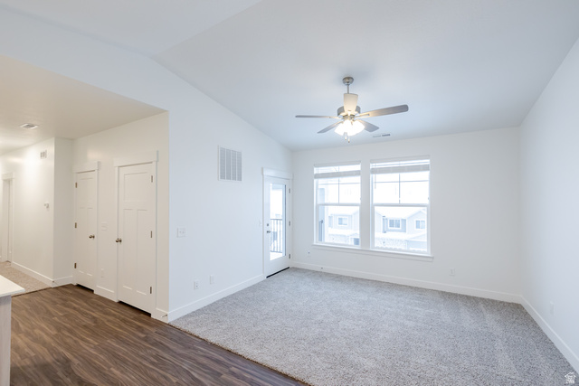 709 West 4500th South, Unit N302 Mapleton, UT 84664 - Photo 13 of 15 Empty room featuring vaulted ceiling, dark wood finished floors, a ceiling fan, and dark colored carpet