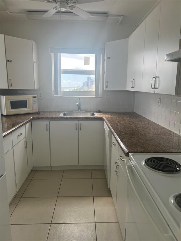 400 North Surf Road, Unit 806 Hollywood, FL 33019 - Photo 17 of 41 a kitchen with a sink a stove top oven and cabinets