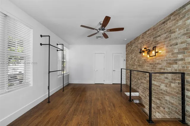 a view of a hallway with wooden floor and a ceiling fan