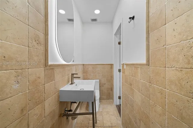 a bathroom with a sink shower and a mirror