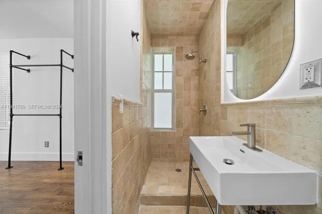 a bathroom with a sink a glass door shower and a mirror
