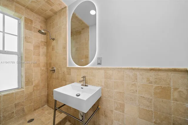 a bathroom with a sink a mirror and a shower