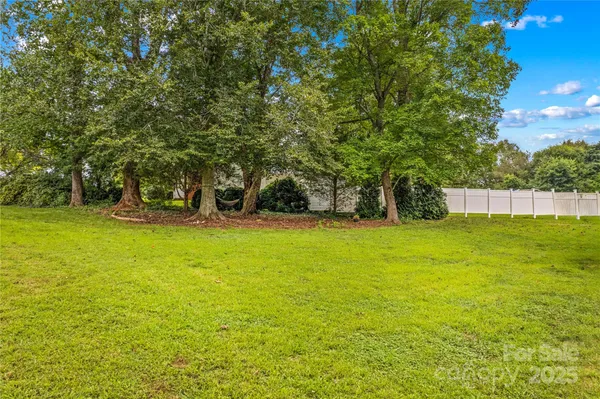 a view of a house with a big yard and large trees