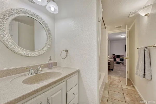 a bathroom with a granite countertop sink and a mirror