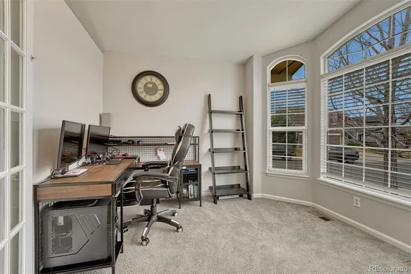 a view of a workspace with furniture and a window