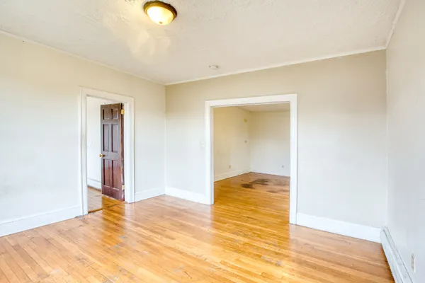 a view of an empty room with wooden floor