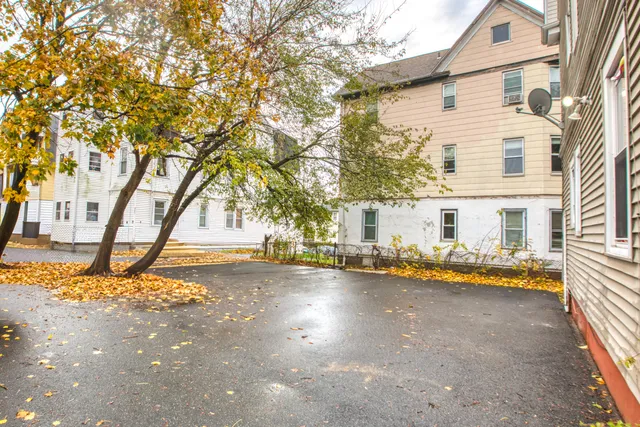 a view of a house with backyard and a tree