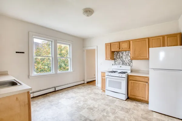a kitchen with a stove a refrigerator and a sink