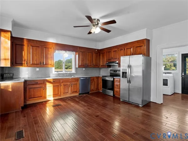 a kitchen with stainless steel appliances granite countertop a sink stove and cabinets