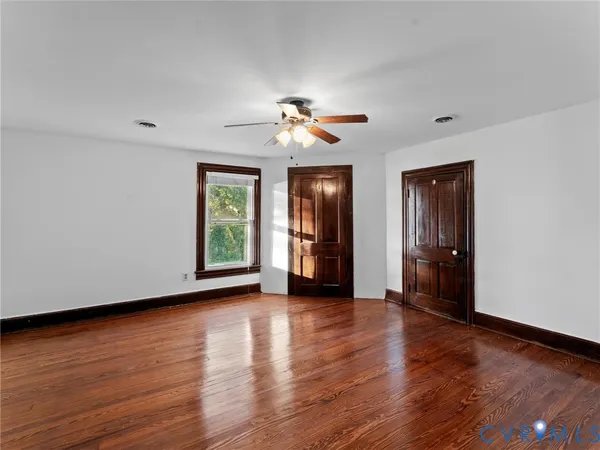 a view of a livingroom with a ceiling fan and wooden floor