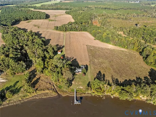 an aerial view of a house with a yard and lake view