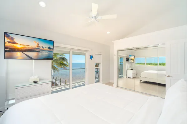 a view of a hallway with wooden floor and a bathroom