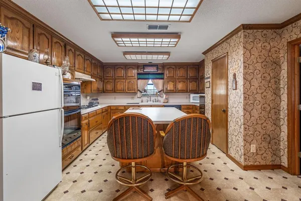 a kitchen with a refrigerator a sink and a chandelier