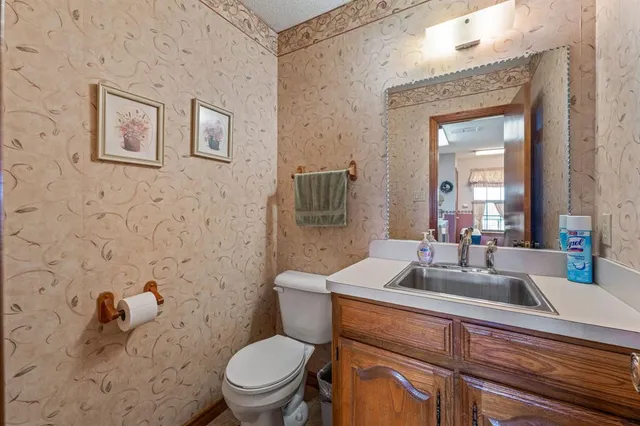 a bathroom with a toilet a sink and mirror