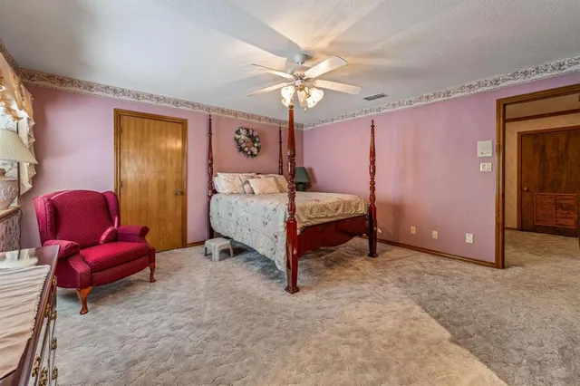 a spacious bedroom with a bed and a chandelier