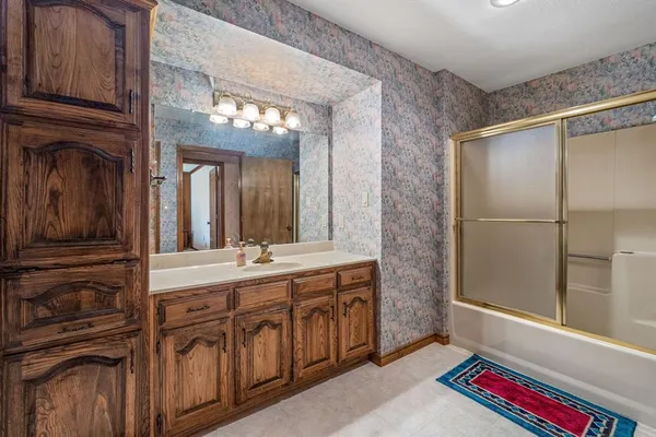a spacious bathroom with a sink a mirror and a shower