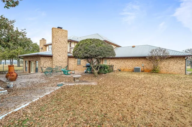 a view of a house with backyard and sitting area
