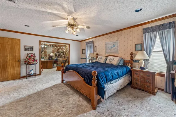 a spacious bedroom with a bed and a chandelier