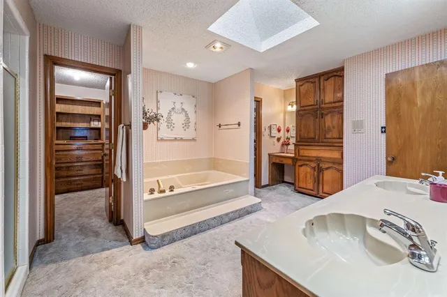 a bathroom with a tub sink and mirror