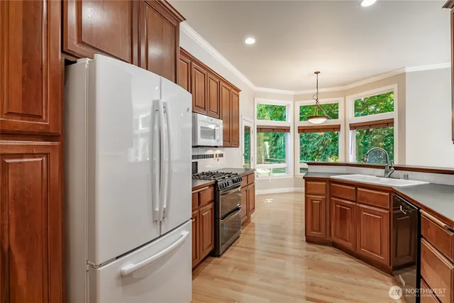 a kitchen with stainless steel appliances a stove a refrigerator and cabinets