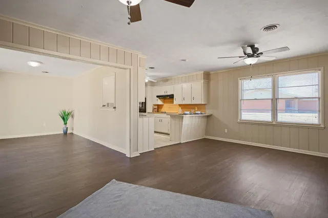 a kitchen with white cabinets and sink