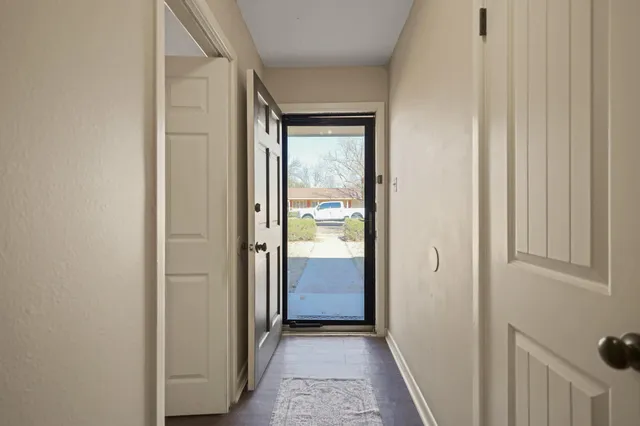 a view of a hallway with a wooden door