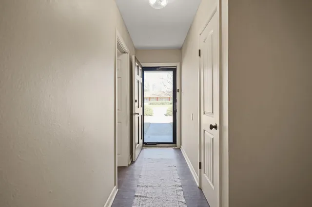 a view of a big room with wooden floor a ceiling fan and windows