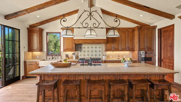 a kitchen with stainless steel appliances granite countertop a sink a stove and a wooden floors