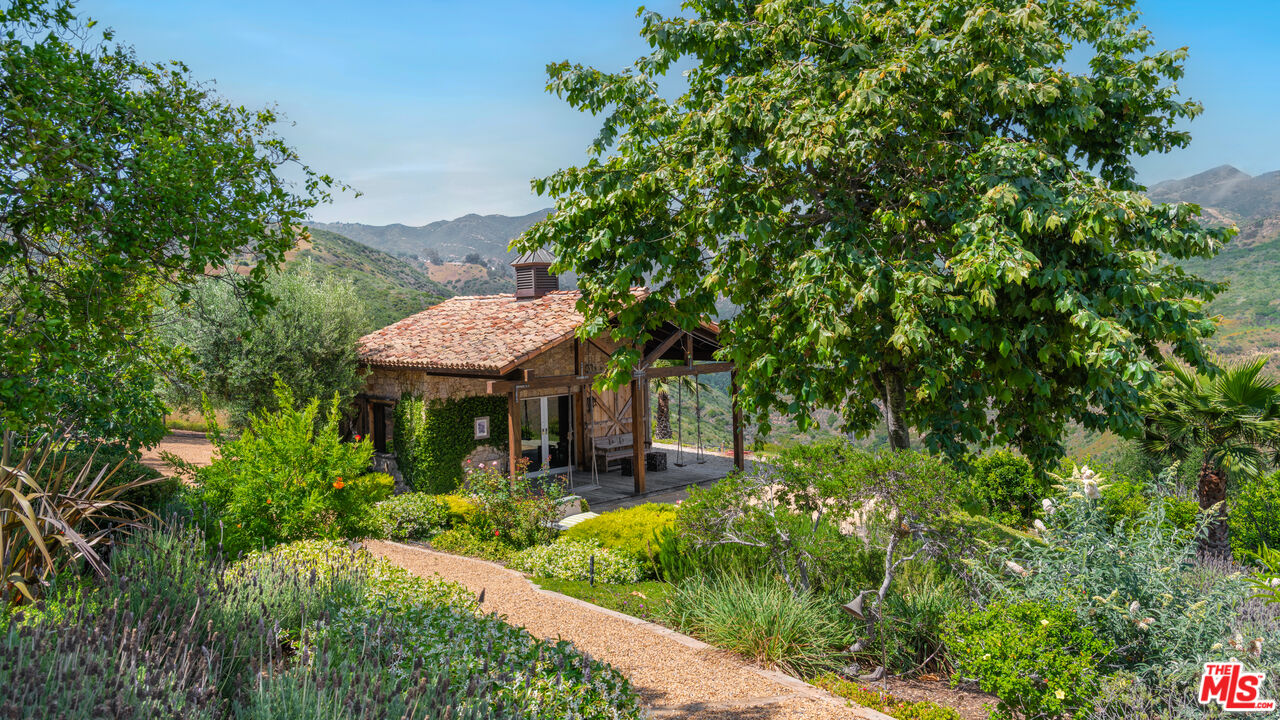 2900 Corral Canyon Road Malibu, CA 90265 - Photo 41 of 48 a view of a patio with table and chairs under an umbrella