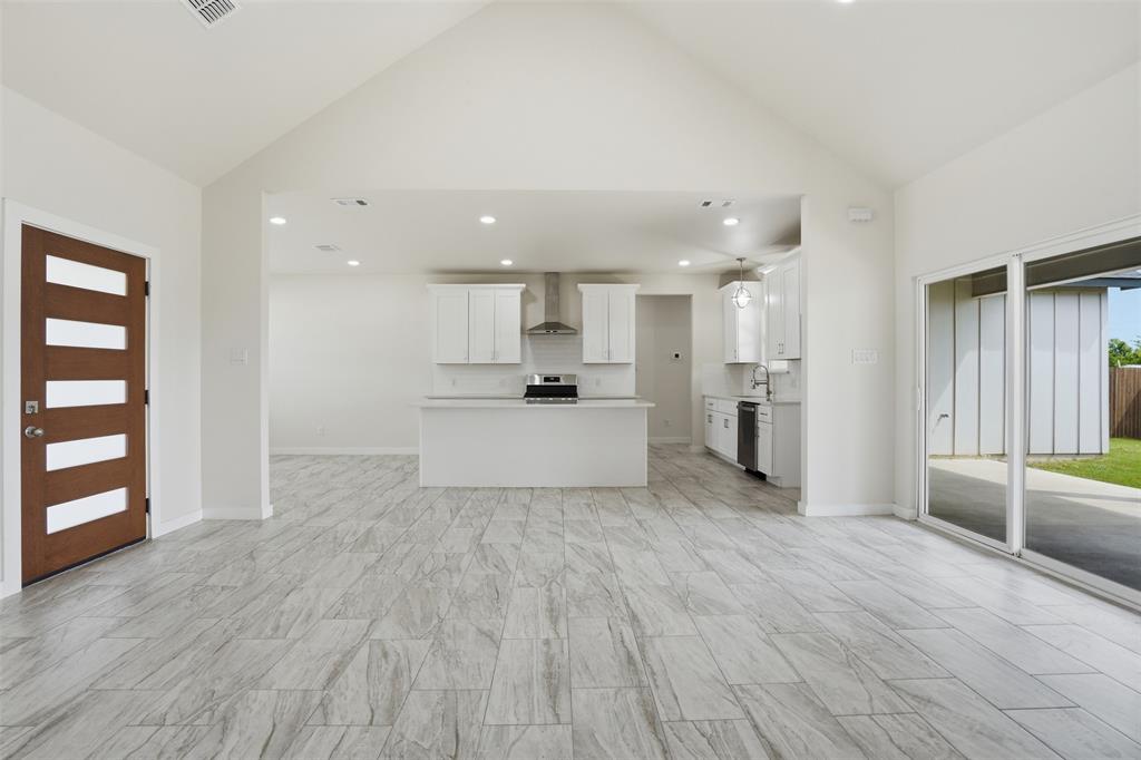 532 Highview Court Godley, TX 76044 - Photo 32 of 39 Spacious living area featuring light gray wood-look flooring and soaring vaulted ceilings