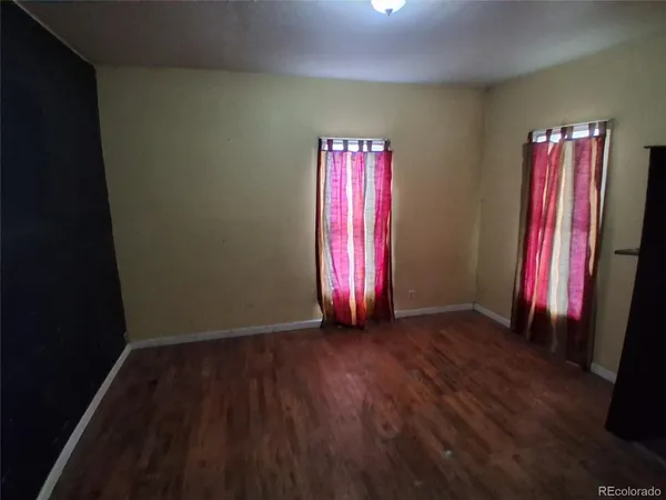 a view of a room with wooden floor and a window