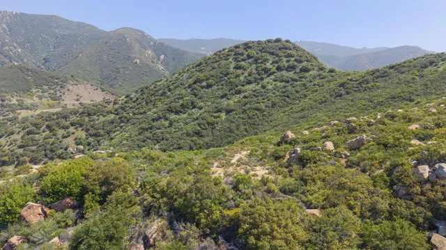 a view of a large mountain with mountains in the background