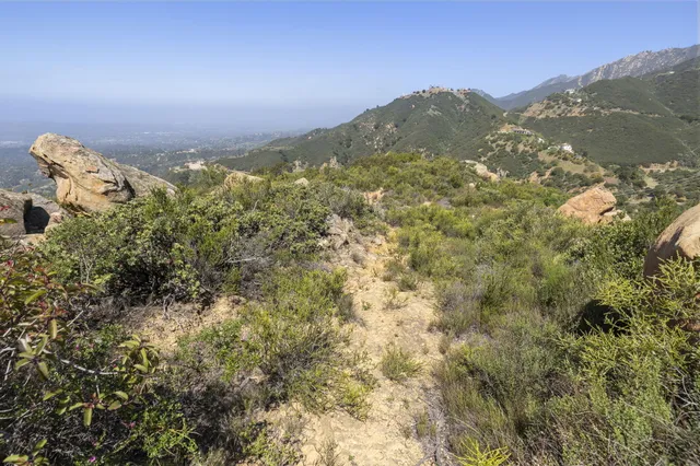 a view of a mountain range with a lush green hillside