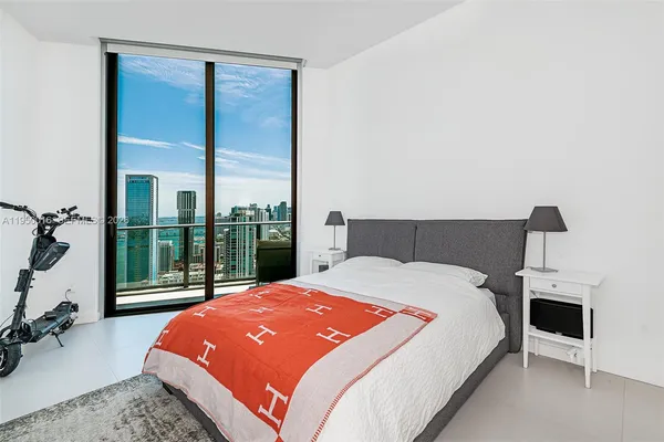 a bedroom with a bed and a large window