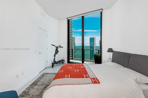 a bedroom with a bed and a large window